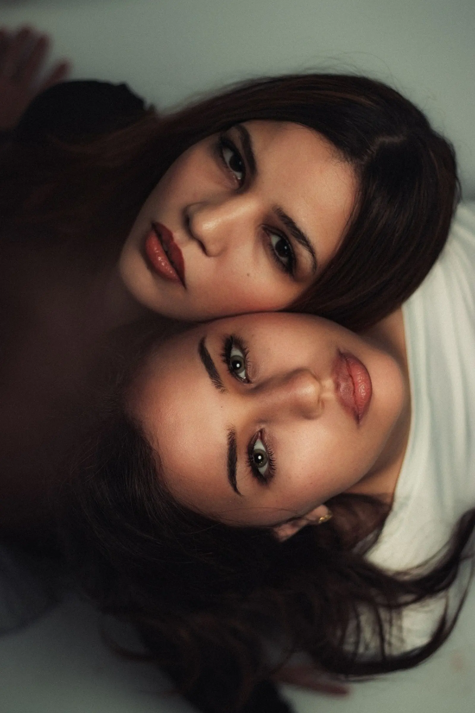 Two women lying head to head, looking calmly into the camera